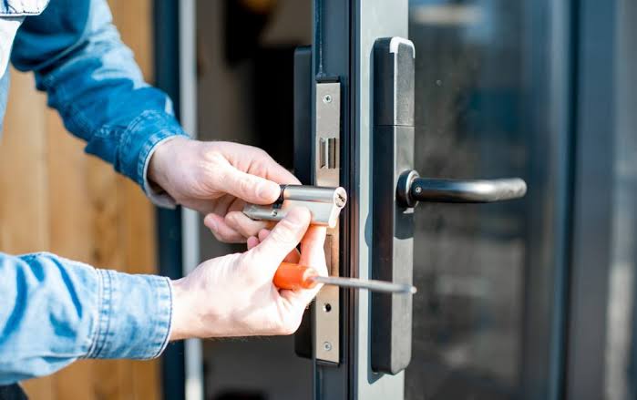 Locksmith working on a commercial glass door lock