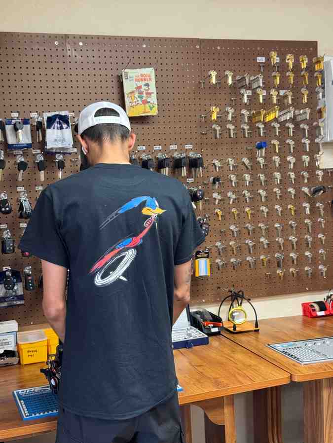 QuicKey locksmith technician in front of a key wall